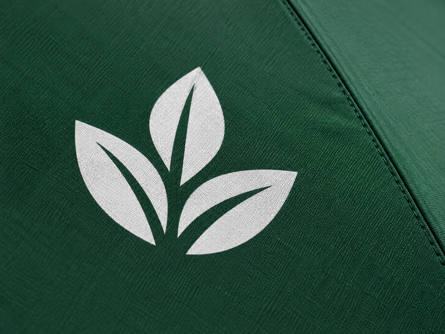 Close-up of a white printed emblem on green umbrella canopy fabric